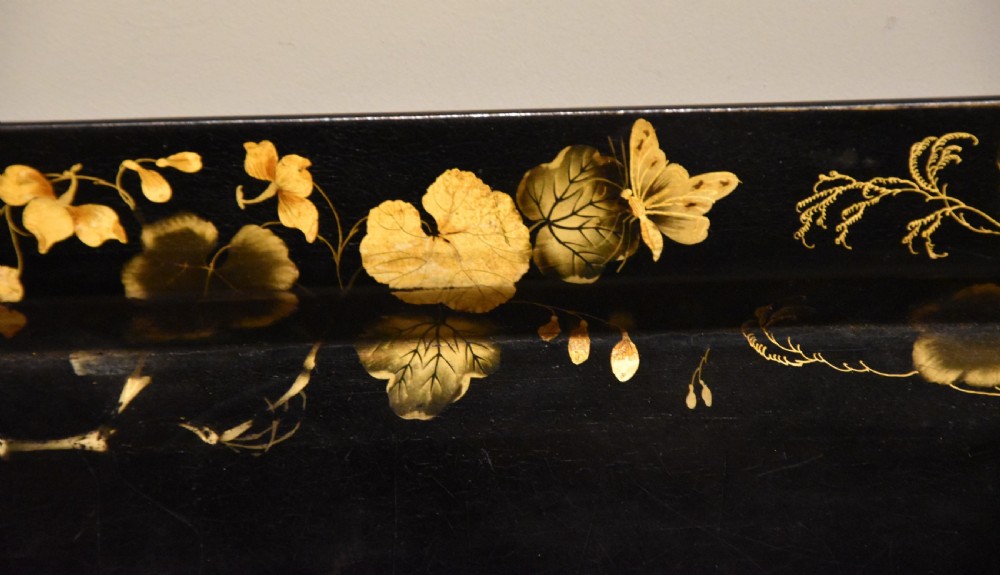 A large rectangular black lacquered Regency papier-mache tray decorated with gilt foliage along its raised rim. View V