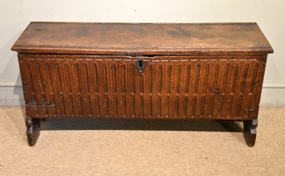 A sixteenth-century dark oak coffer featuring vertical fluted carvings across the front panel and a metal keyhole escutcheon. View II