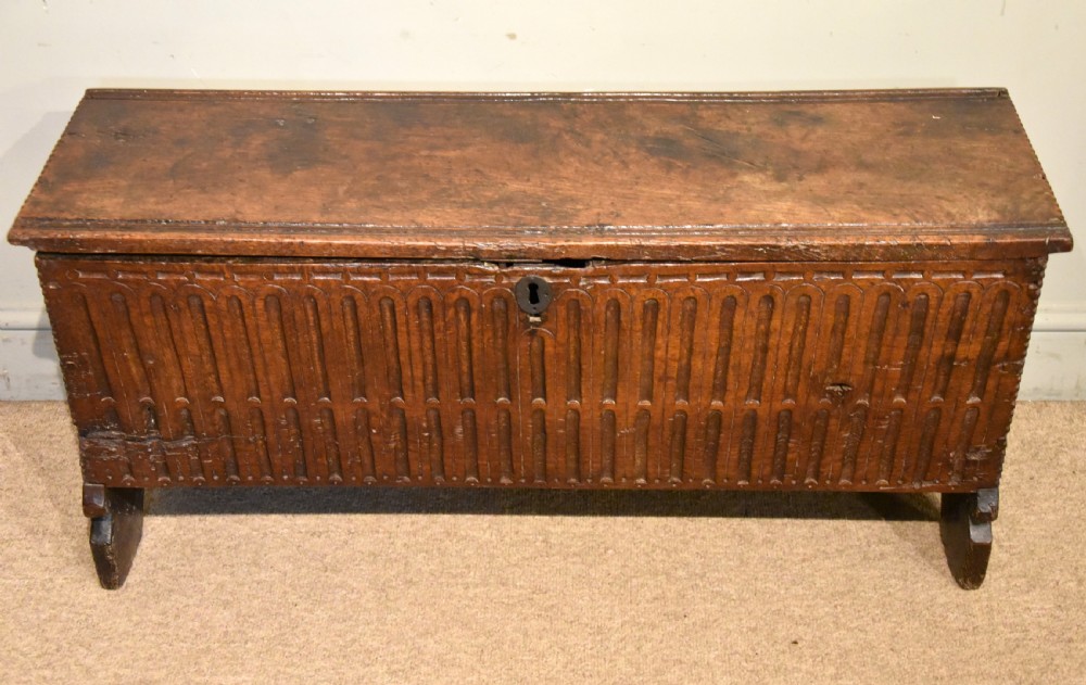 A sixteenth-century dark oak coffer featuring vertical fluted carvings across the front panel and a metal keyhole escutcheon. View III