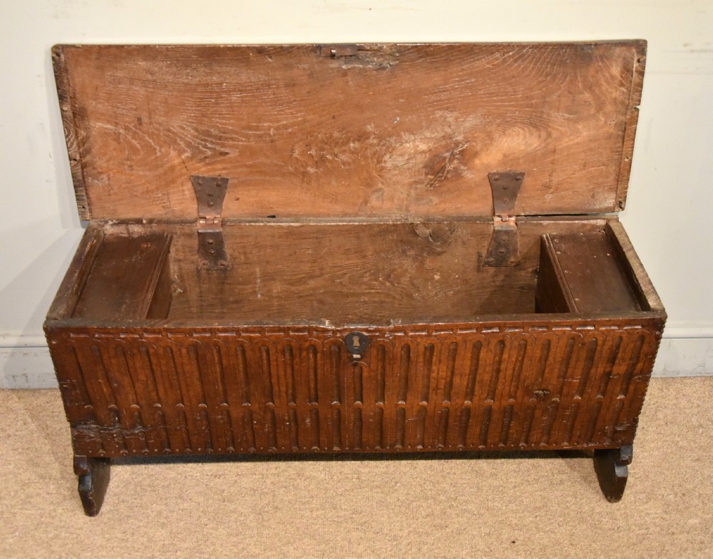 A sixteenth-century dark oak coffer featuring vertical fluted carvings across the front panel and a metal keyhole escutcheon. View IV