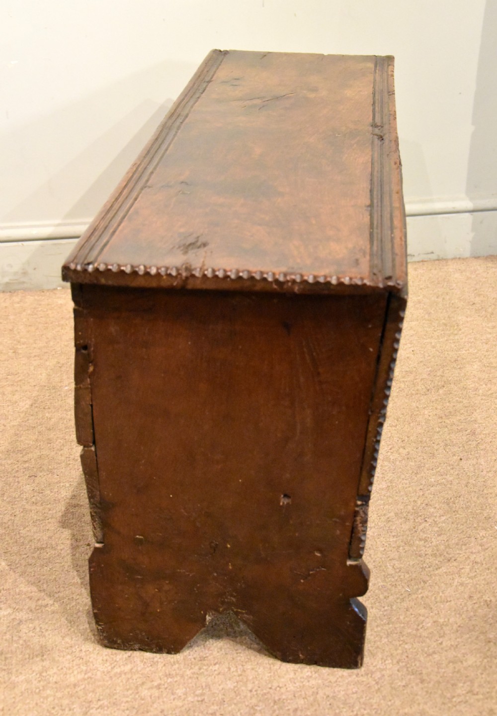 A sixteenth-century dark oak coffer featuring vertical fluted carvings across the front panel and a metal keyhole escutcheon. View VII