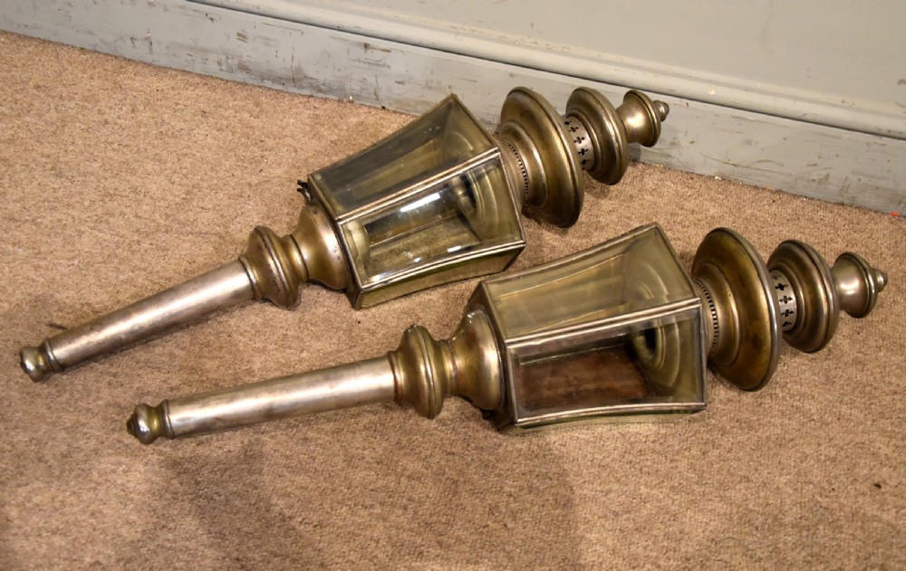 A pair of late nineteenth-century metal coaching lamps featuring glass panes, tiered upper vents, and long cylindrical mounting stems. View II