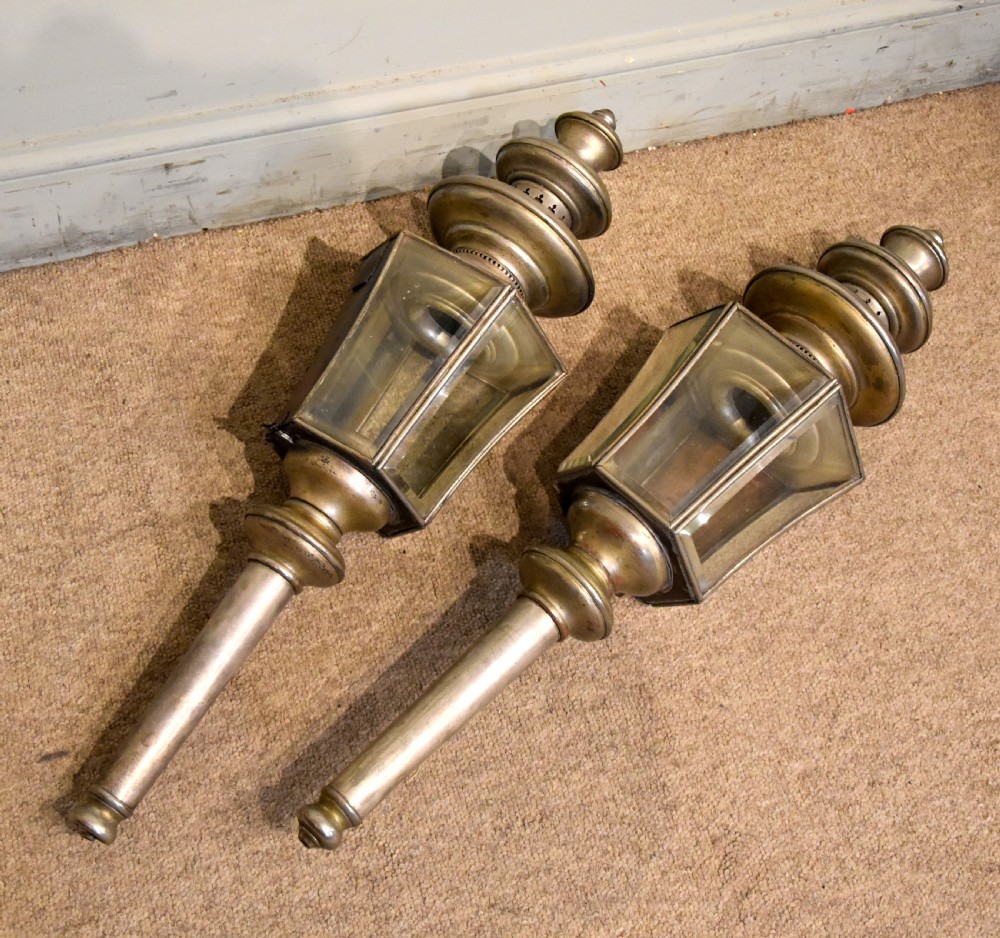 A pair of late nineteenth-century metal coaching lamps featuring glass panes, tiered upper vents, and long cylindrical mounting stems. View III