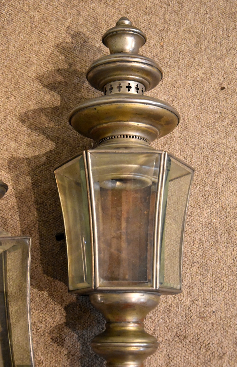 A pair of late nineteenth-century metal coaching lamps featuring glass panes, tiered upper vents, and long cylindrical mounting stems. View IV