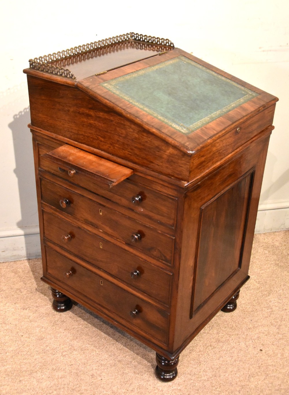 A Regency rosewood Davenport desk featuring a slanted green leather writing slope, a brass gallery rail, and four side drawers with turned wooden knobs. View III