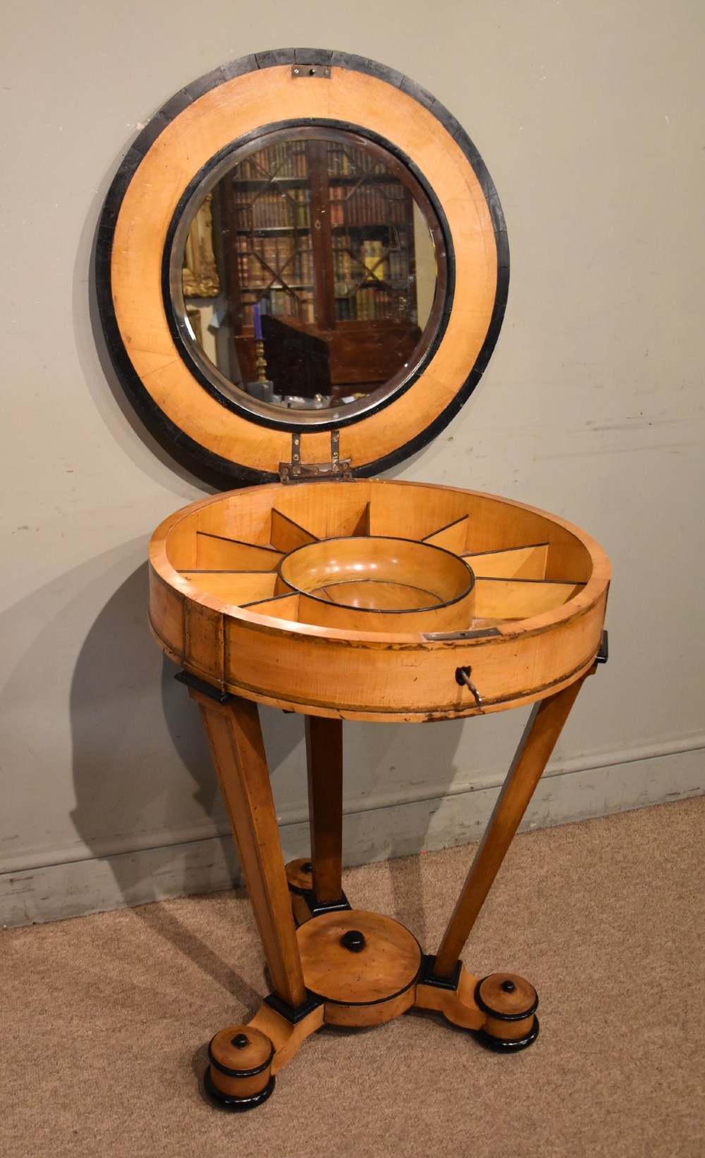 A circular Biedermeier centre table featuring a painted classical top panel, golden birch veneer apron with key, ebonised trim, and a tripod base. View II