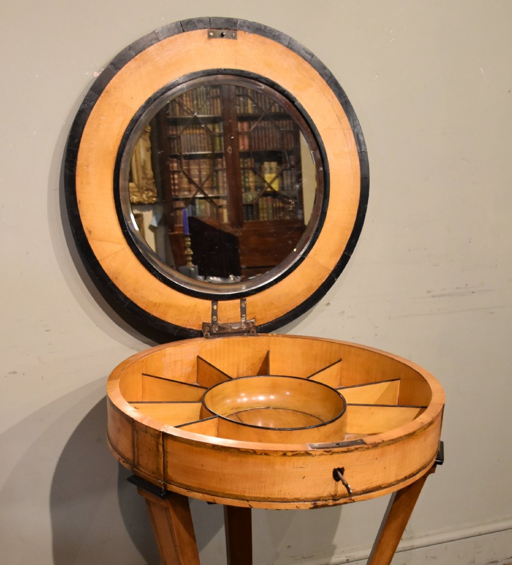 A circular Biedermeier centre table featuring a painted classical top panel, golden birch veneer apron with key, ebonised trim, and a tripod base. View III