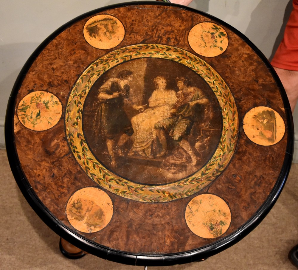 A circular Biedermeier centre table featuring a painted classical top panel, golden birch veneer apron with key, ebonised trim, and a tripod base. View VIII