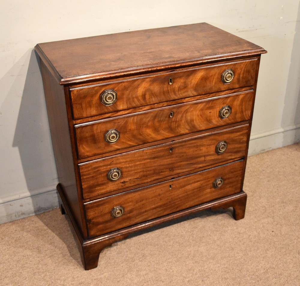 An 18th-century George III mahogany chest featuring four graduated drawers with flame mahogany veneer, octagonal brass handles, and bracket feet. View II