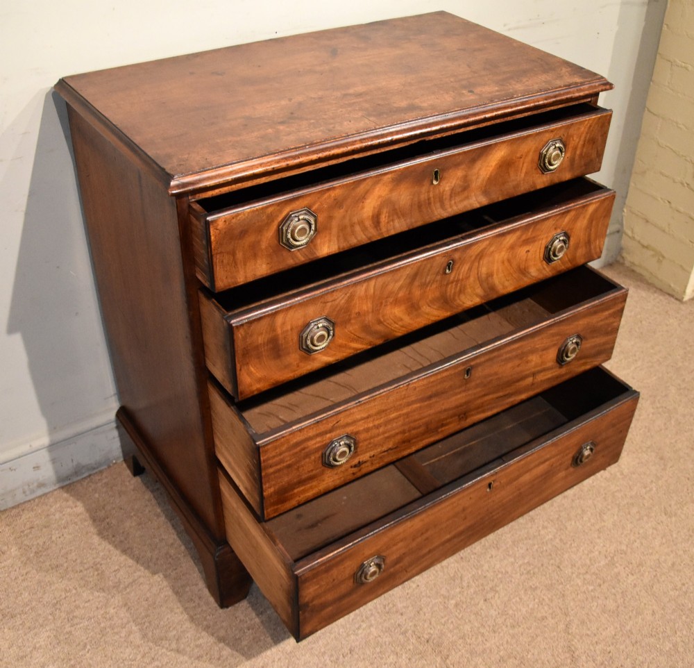 An 18th-century George III mahogany chest featuring four graduated drawers with flame mahogany veneer, octagonal brass handles, and bracket feet. View III