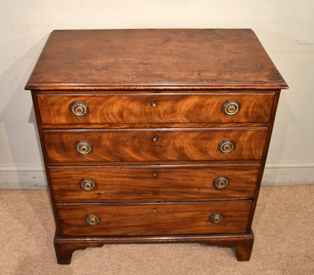 An 18th-century George III mahogany chest featuring four graduated drawers with flame mahogany veneer, octagonal brass handles, and bracket feet. View IV