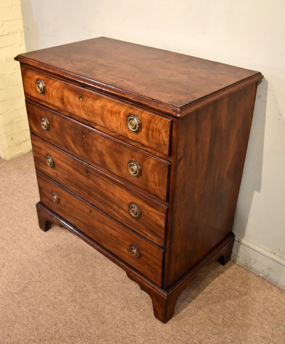 An 18th-century George III mahogany chest featuring four graduated drawers with flame mahogany veneer, octagonal brass handles, and bracket feet. View V