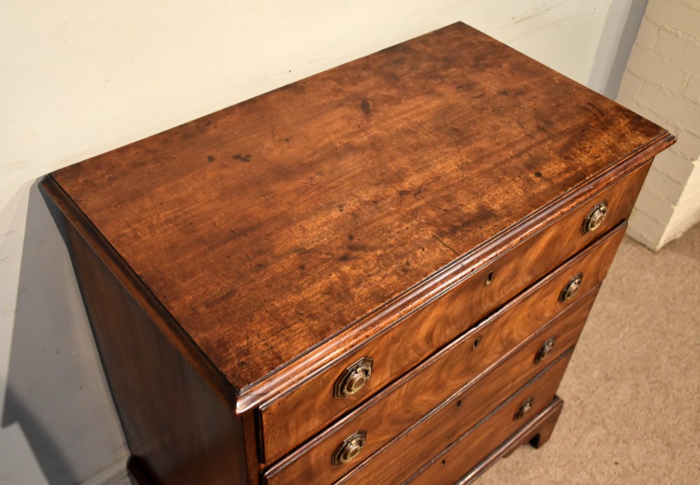 An 18th-century George III mahogany chest featuring four graduated drawers with flame mahogany veneer, octagonal brass handles, and bracket feet. View VII