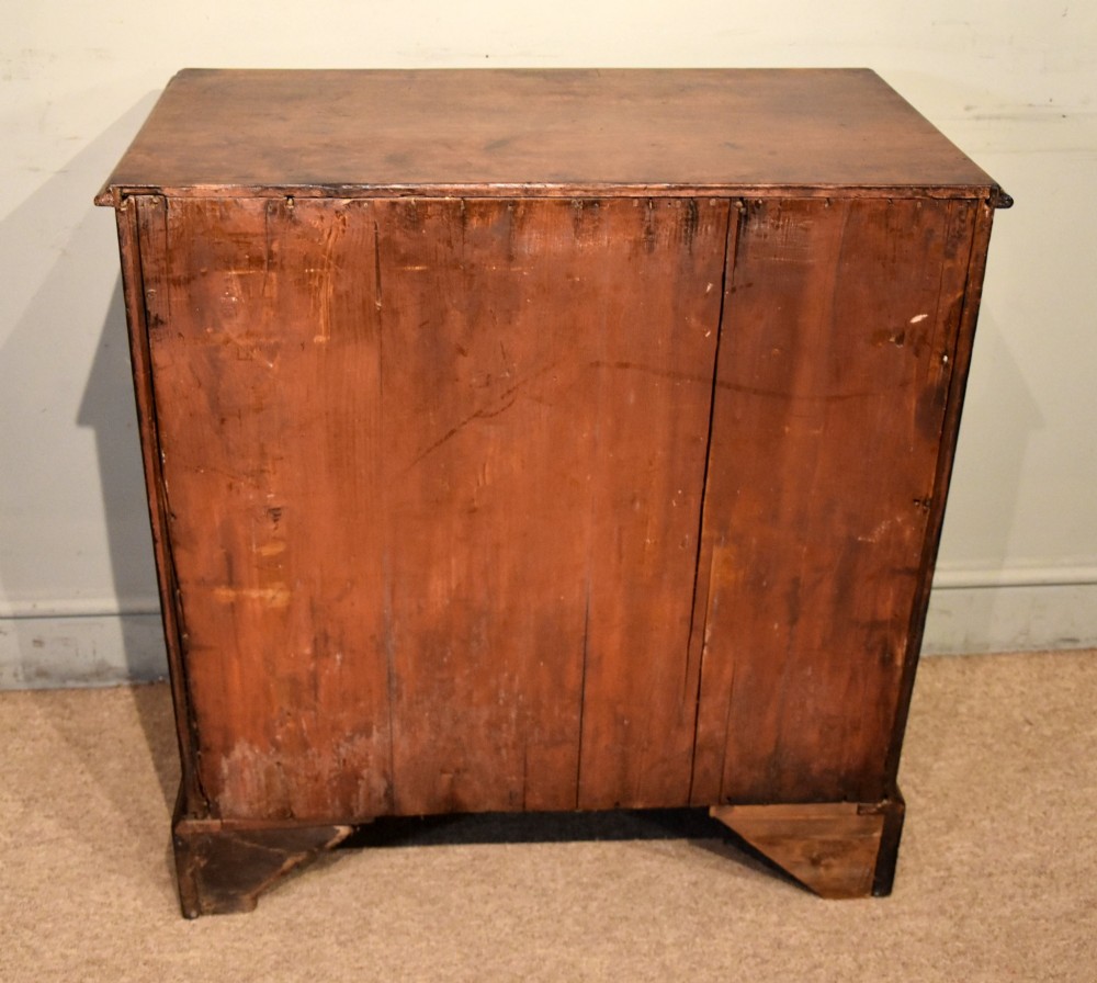 An 18th-century George III mahogany chest featuring four graduated drawers with flame mahogany veneer, octagonal brass handles, and bracket feet. View IX