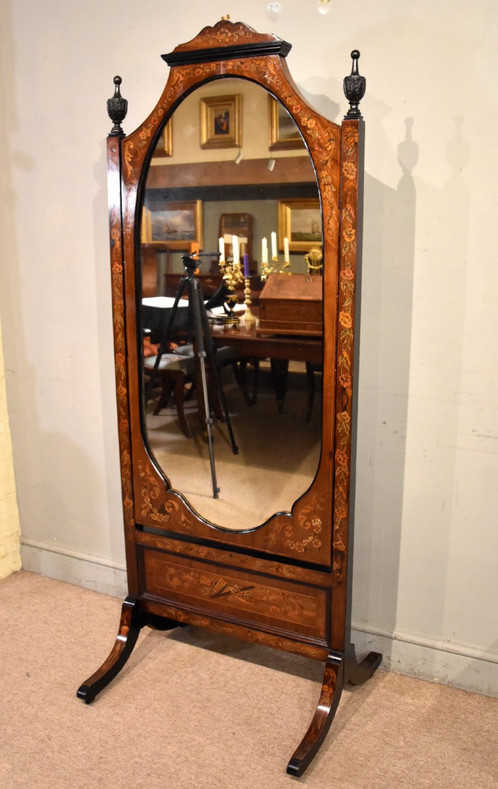 A Victorian mahogany cheval mirror featuring detailed floral marquetry inlays, carved urn finials, an arched glass frame, and splayed feet. View II