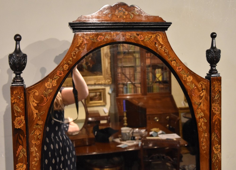 A Victorian mahogany cheval mirror featuring detailed floral marquetry inlays, carved urn finials, an arched glass frame, and splayed feet. View IV