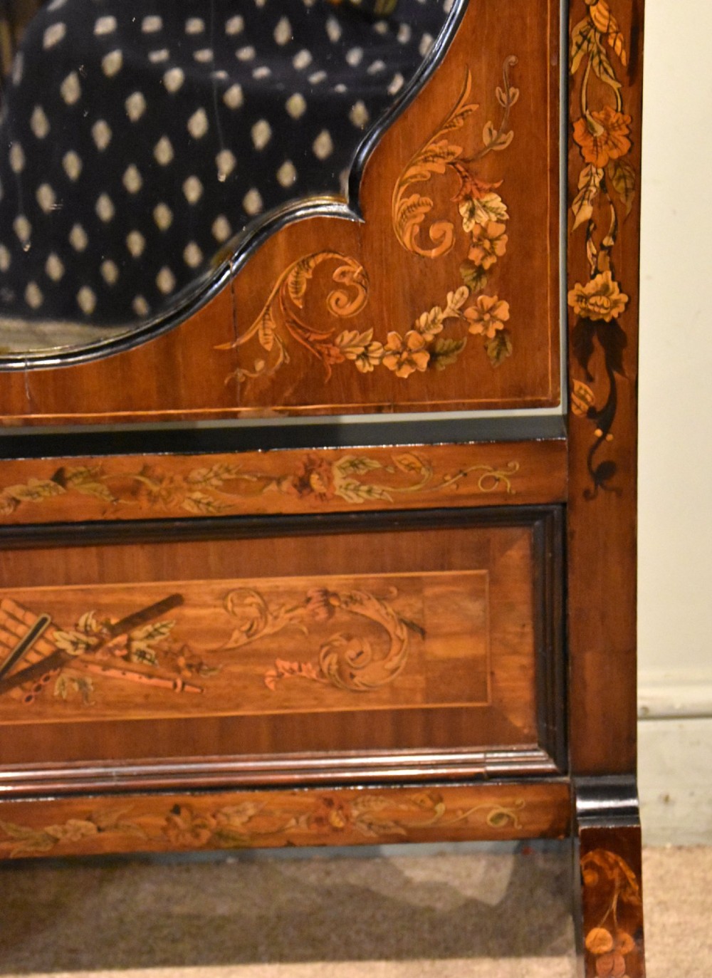 A Victorian mahogany cheval mirror featuring detailed floral marquetry inlays, carved urn finials, an arched glass frame, and splayed feet. View VI