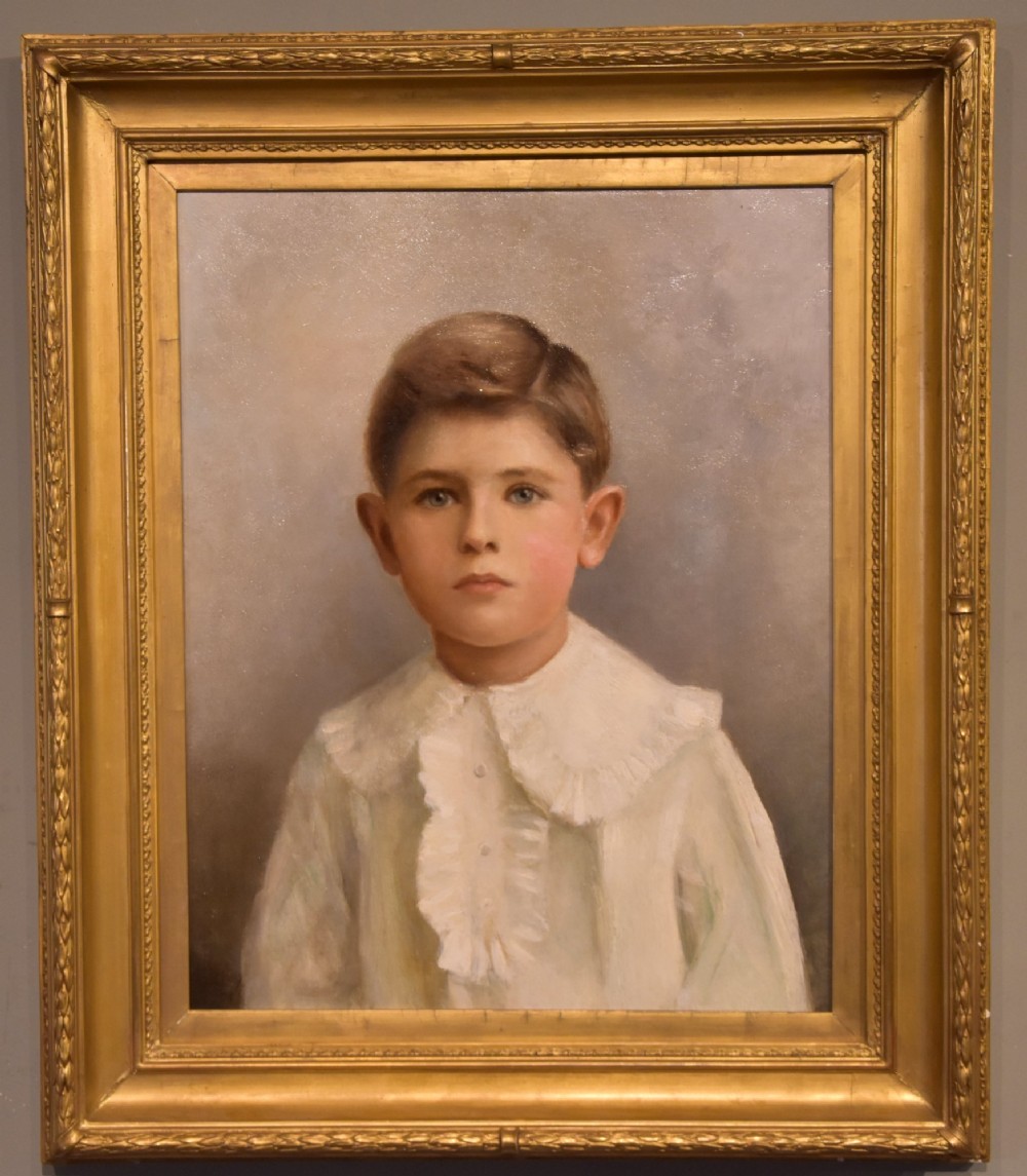 An antique framed oil painting on canvas depicting a young boy wearing a white ruffled collar.