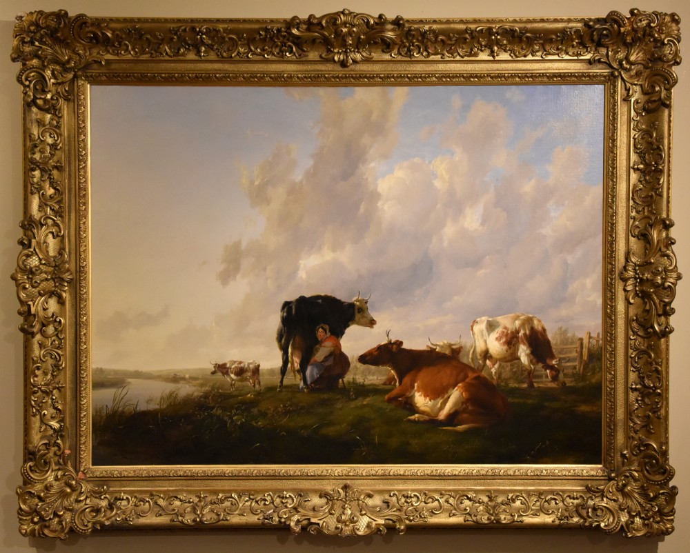 A 19th-century Victorian pastoral oil painting featuring cattle and a milkmaid near a river in an intricate gilded frame.