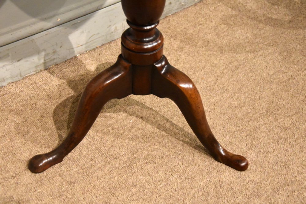 A small Georgian mahogany tripod wine table featuring a circular top, turned central baluster pedestal, and three cabriole legs with pad feet. View IV