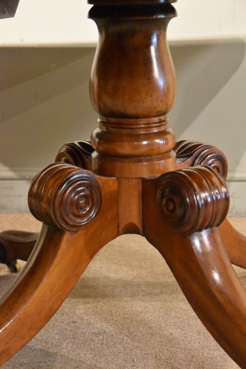 A Regency period mahogany extending dining table supported by two turned pedestal bases with reeded splayed legs and brass castors. View VII