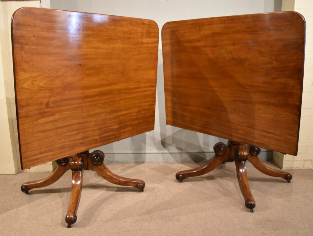 A Regency period mahogany extending dining table supported by two turned pedestal bases with reeded splayed legs and brass castors. View IX