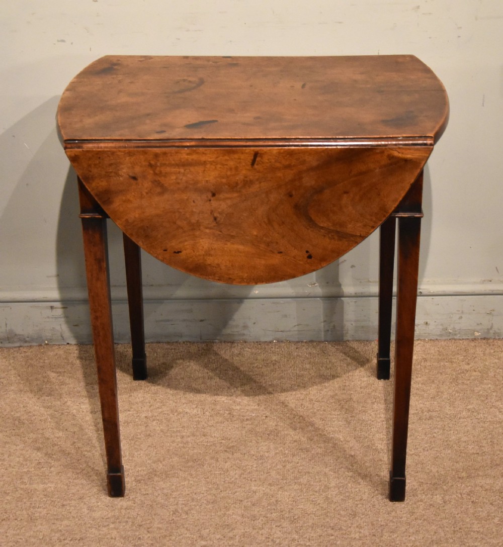 An 18th-century Georgian mahogany Pembroke table featuring an oval drop-leaf top, a frieze drawer with a brass handle, and four square tapered legs. View IV