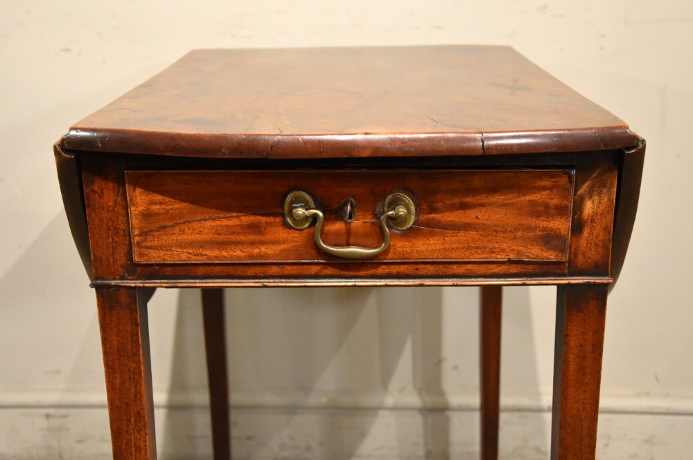 An 18th-century Georgian mahogany Pembroke table featuring an oval drop-leaf top, a frieze drawer with a brass handle, and four square tapered legs. View VII