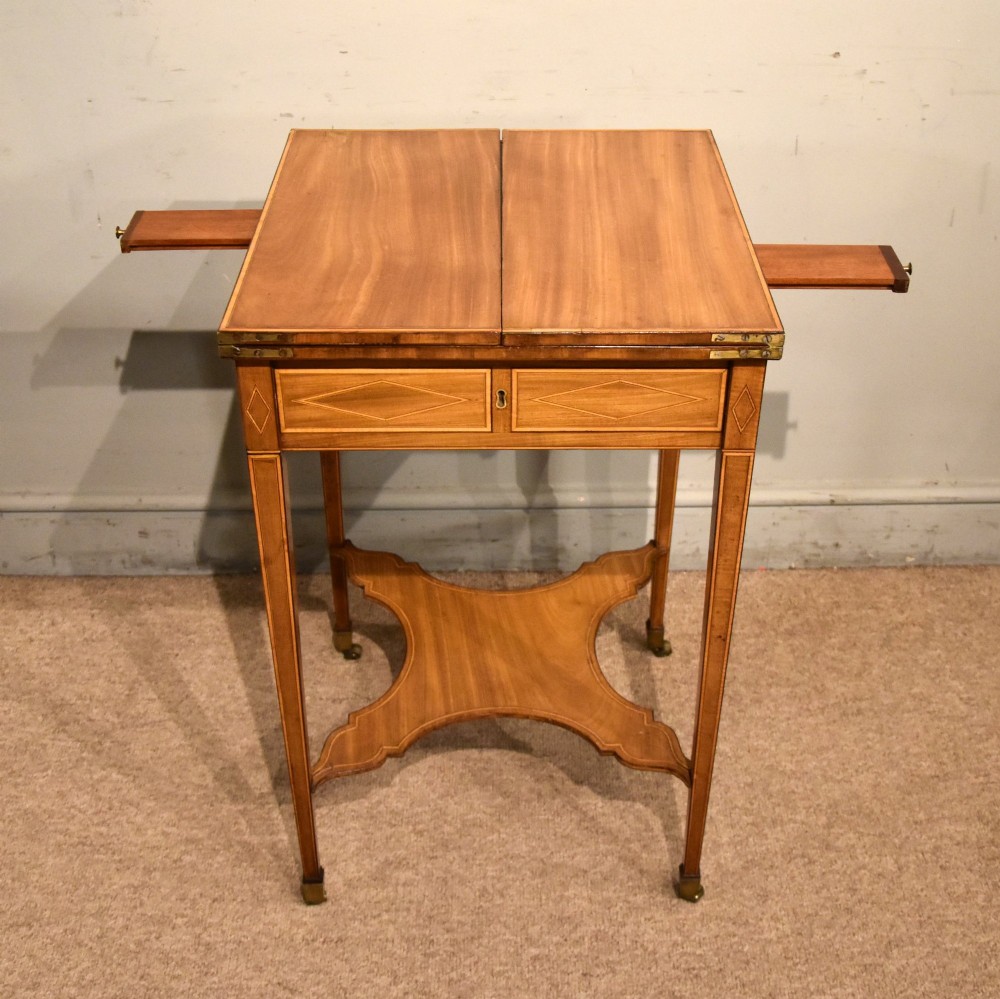 A Sheraton period mahogany writing table featuring folding side leaves, a green leather inset writing surface, diamond marquetry inlay, and a lower shaped stretcher. View III