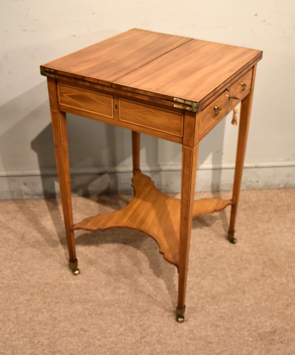 A Sheraton period mahogany writing table featuring folding side leaves, a green leather inset writing surface, diamond marquetry inlay, and a lower shaped stretcher. View VI