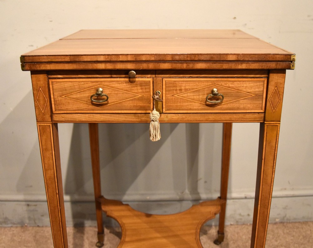 A Sheraton period mahogany writing table featuring folding side leaves, a green leather inset writing surface, diamond marquetry inlay, and a lower shaped stretcher. View VII