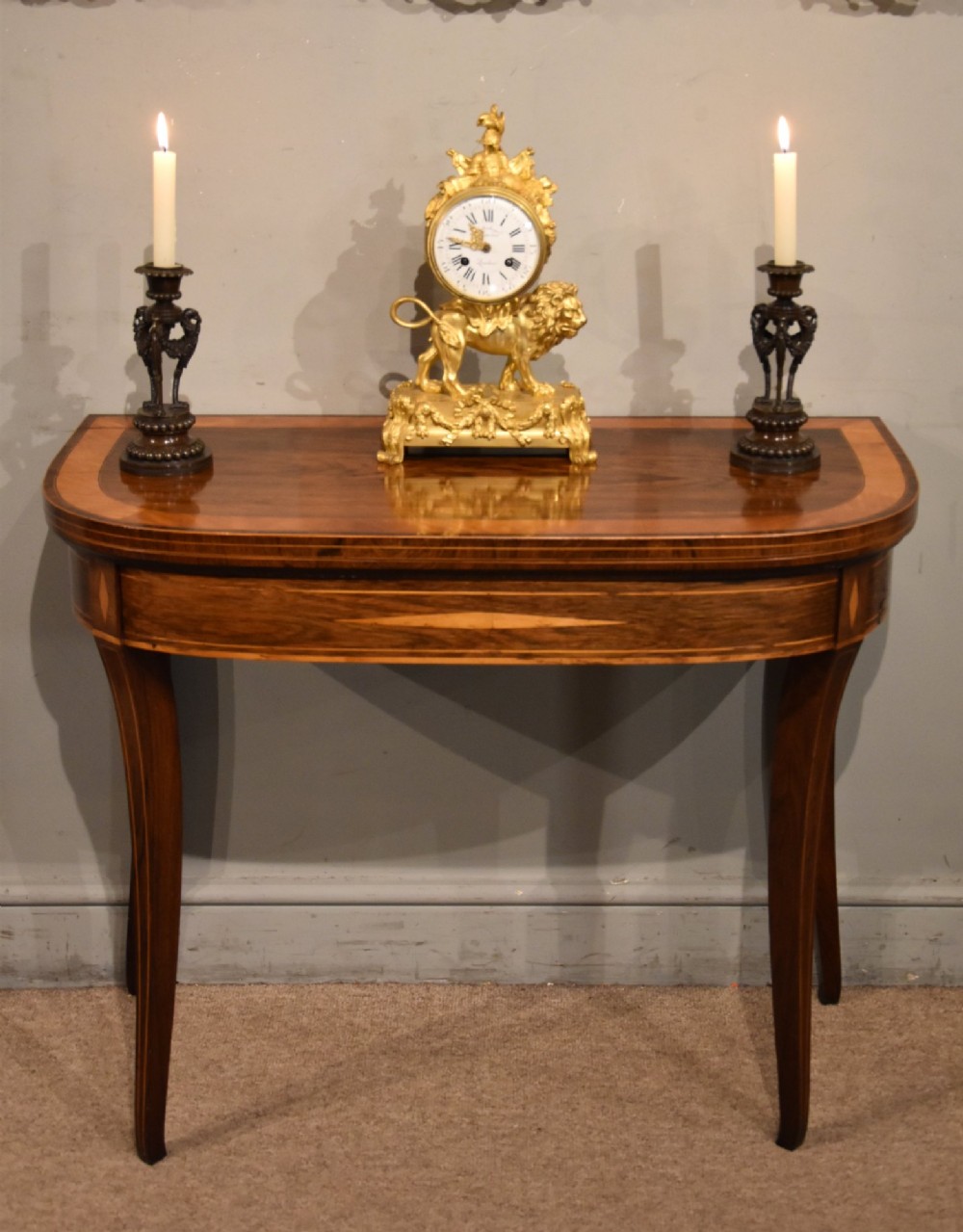 A Regency rosewood foldover card table featuring satinwood crossbanding and an inlaid diamond motif on swept legs. View II