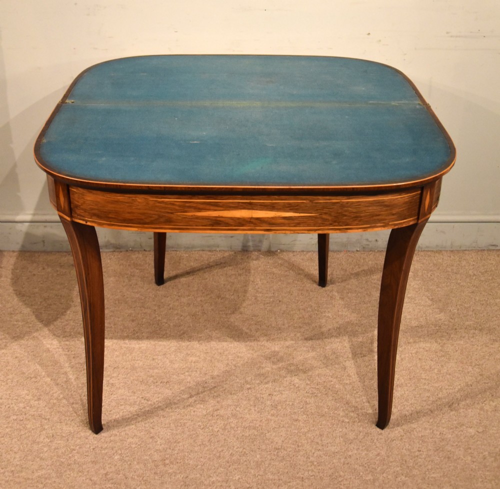 A Regency rosewood foldover card table featuring satinwood crossbanding and an inlaid diamond motif on swept legs. View VI