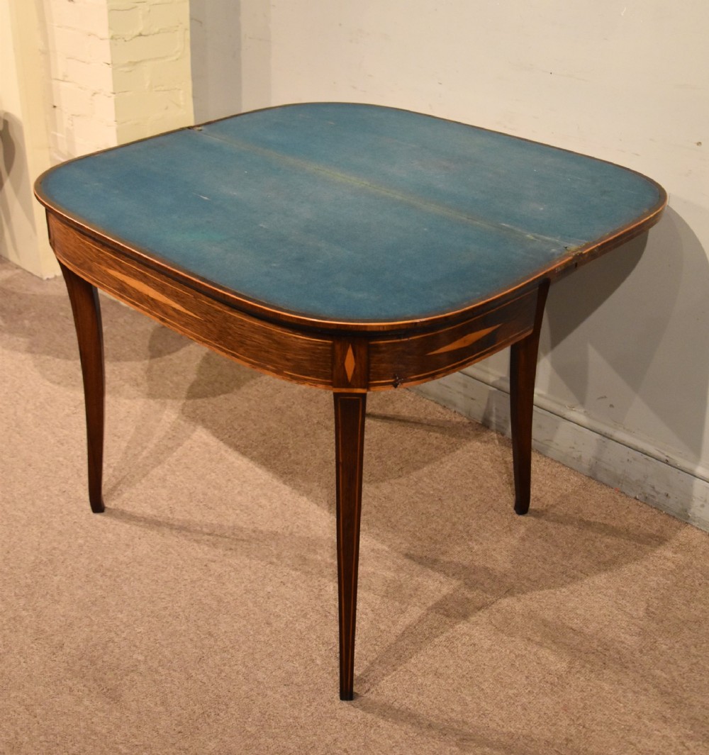 A Regency rosewood foldover card table featuring satinwood crossbanding and an inlaid diamond motif on swept legs. View VII