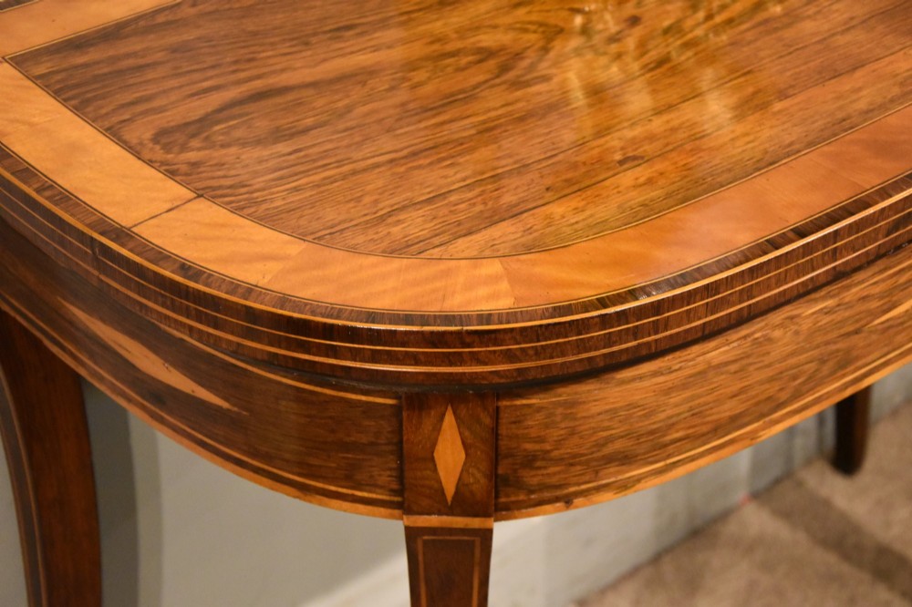 A Regency rosewood foldover card table featuring satinwood crossbanding and an inlaid diamond motif on swept legs. View VIII