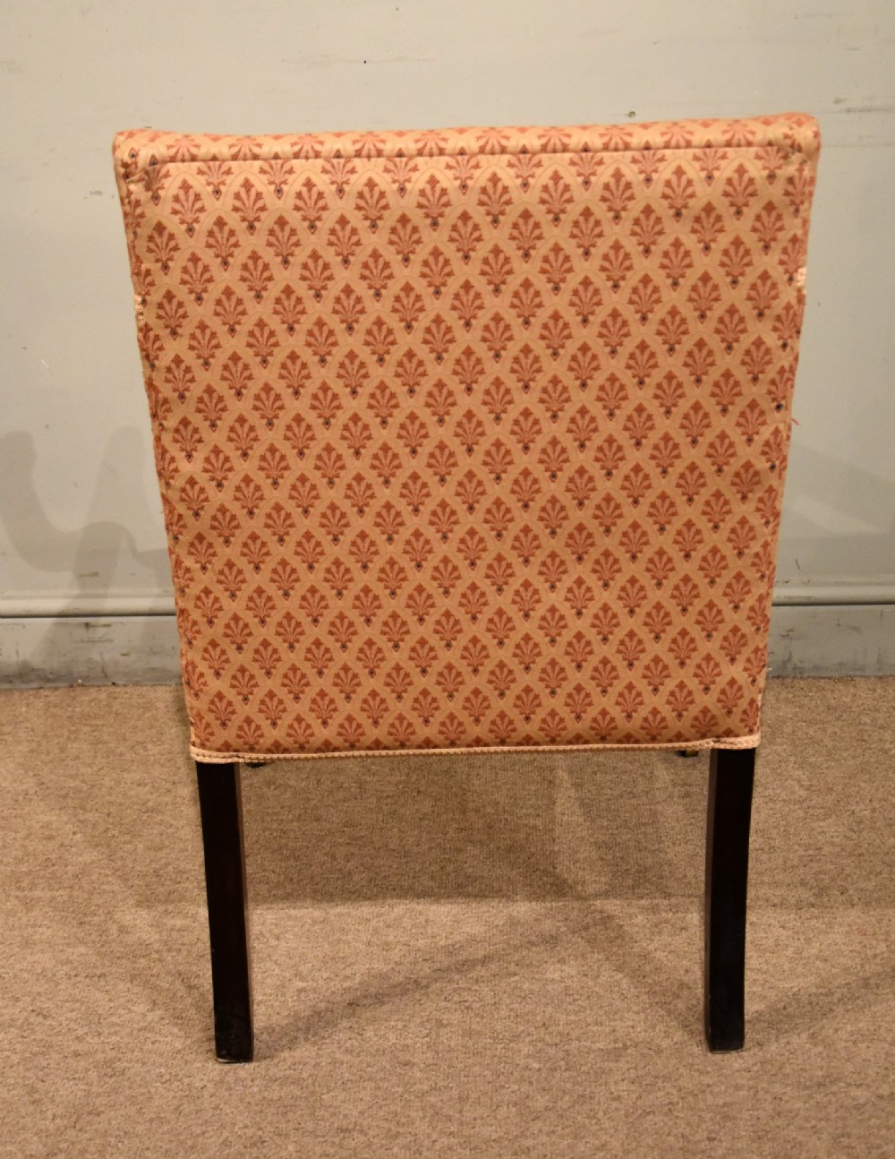A pair of antique mahogany armchairs featuring terracotta pattern upholstery, sweeping armrests, turned front legs, and brass castors. View VI