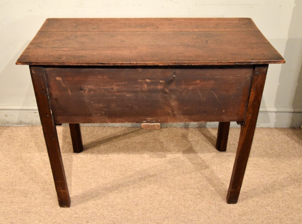 A George III oak lowboy side table featuring one wide upper drawer above two smaller drawers, fitted with brass swan-neck handles, a scalloped apron, and reeded square legs. View VII
