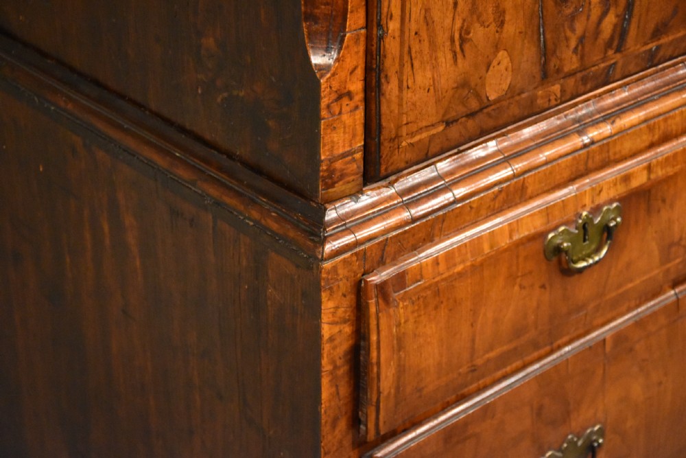 A George III walnut chest on chest featuring two short over three long drawers on the upper section and two short over two long drawers below, set on bracket feet with brass handles. View V