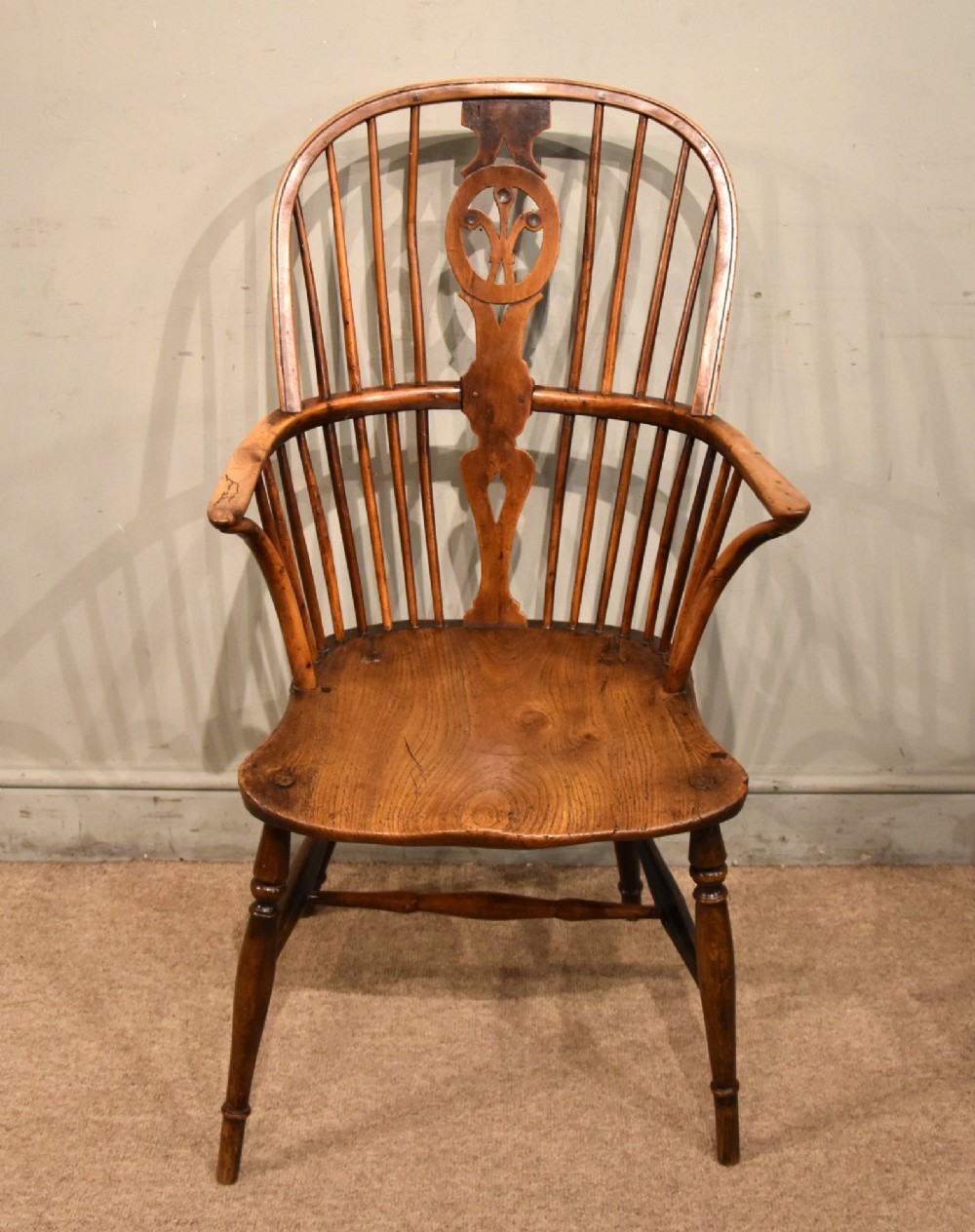 A pair of antique Welsh high-back Windsor armchairs crafted from warm brown elm, featuring pierced splats, spindle backs, shaped seats, and turned legs joined by stretchers. View II