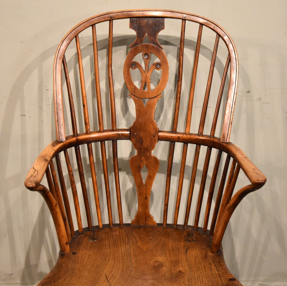 A pair of antique Welsh high-back Windsor armchairs crafted from warm brown elm, featuring pierced splats, spindle backs, shaped seats, and turned legs joined by stretchers. View VI