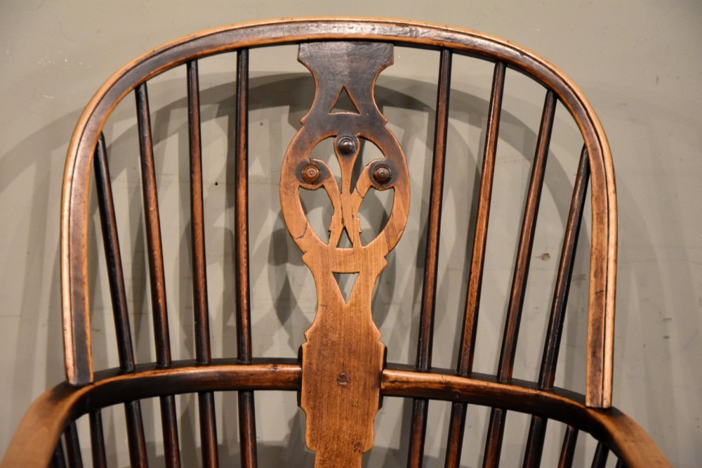 A pair of antique Welsh high-back Windsor armchairs crafted from warm brown elm, featuring pierced splats, spindle backs, shaped seats, and turned legs joined by stretchers. View VII