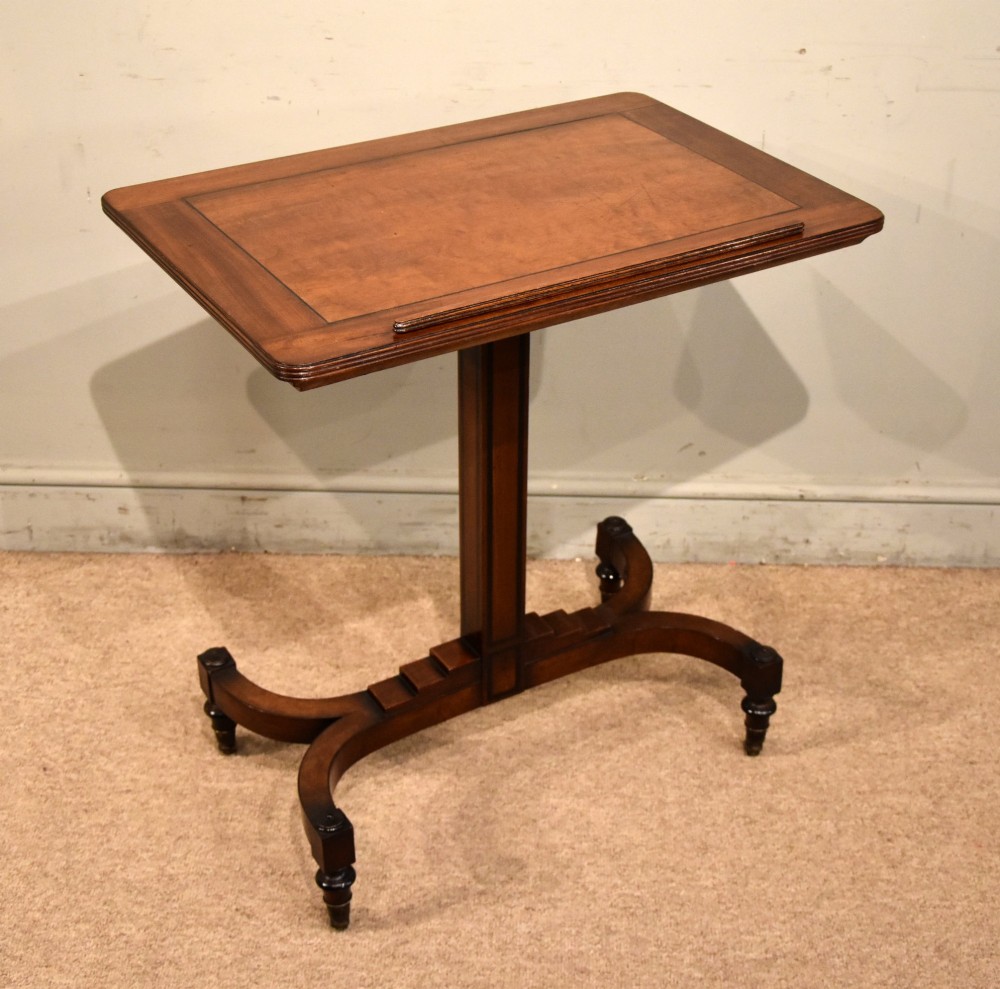 A Regency period mahogany reading stand featuring a rectangular tilting top resting on a central pedestal column with splayed legs and brass castors. View V