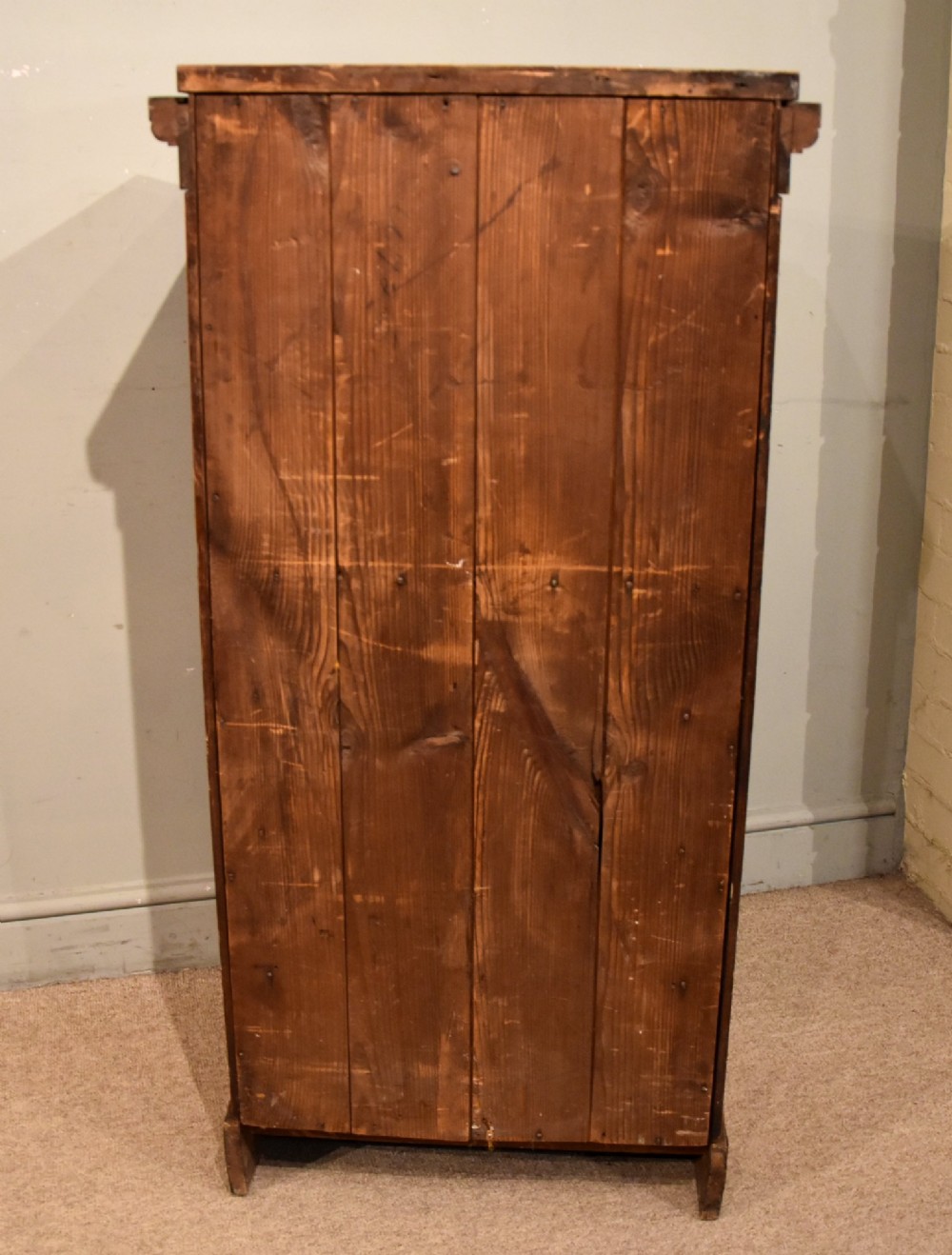A tall Victorian satin birch Wellington chest featuring multiple drawers, a top secretaire compartment, turned wooden knobs, and a hinged side locking bar on a plinth base. View VII