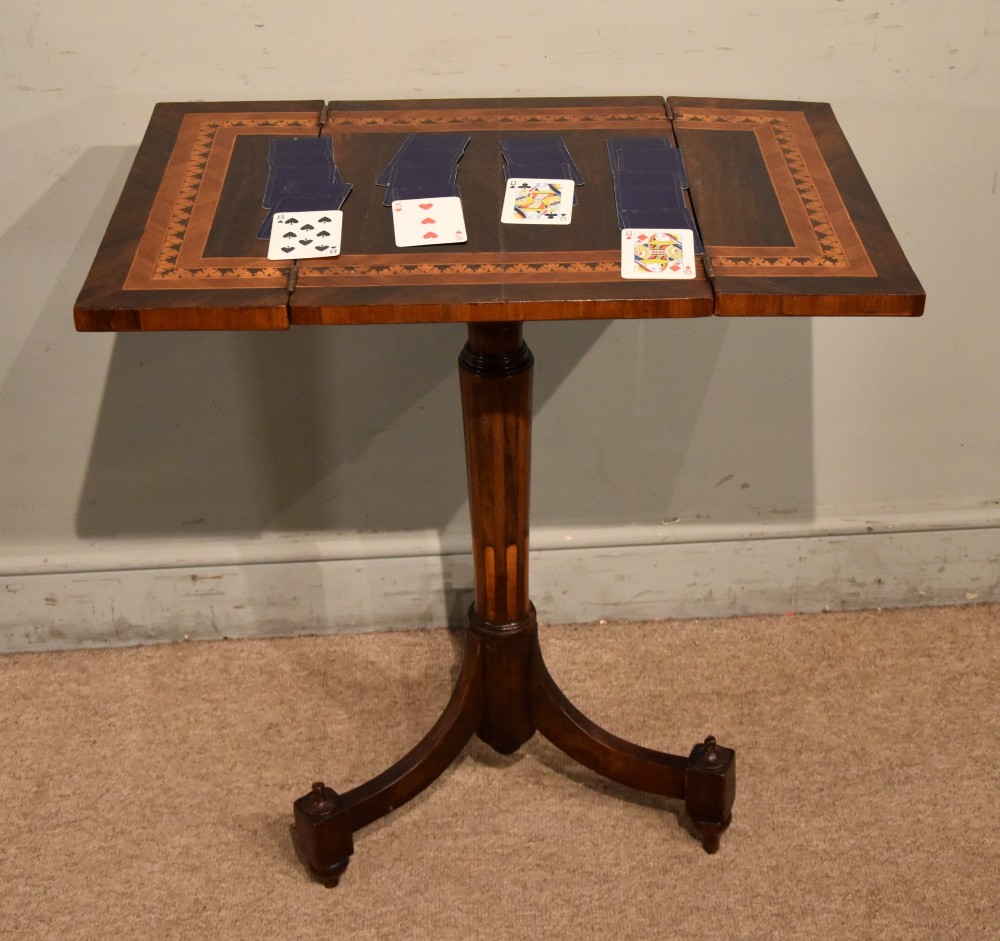 A Regency period patience table featuring an olive wood and satinwood inlaid top on a turned pedestal with three splayed legs. View V