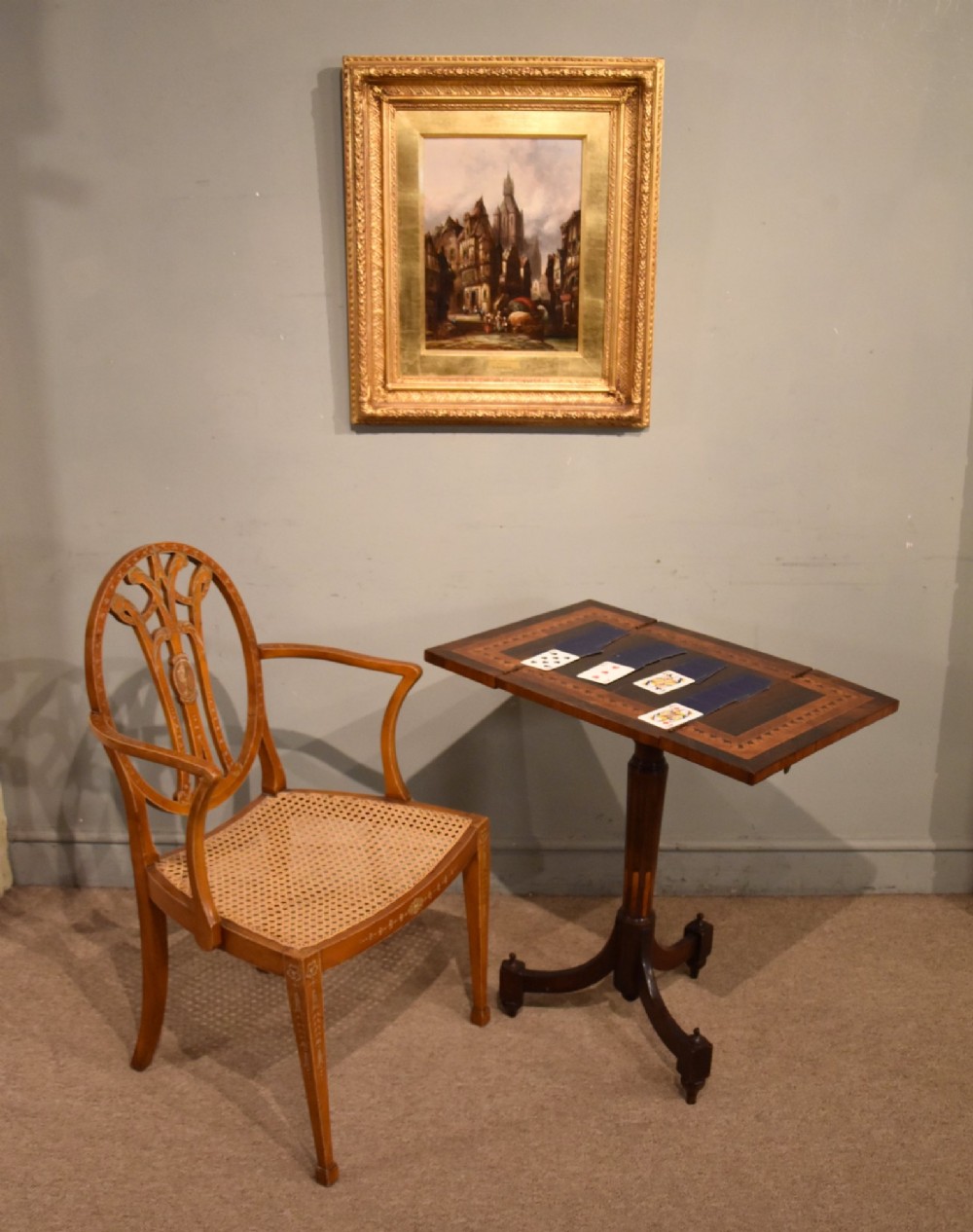 A Regency period patience table featuring an olive wood and satinwood inlaid top on a turned pedestal with three splayed legs. View VII