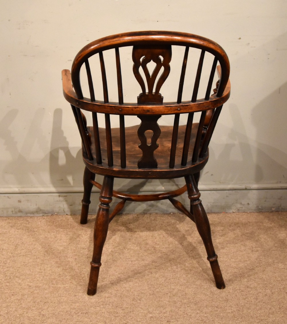 An early 19th-century yew wood Windsor armchair featuring a curved hoop back, pierced splat, turned legs, and a crinoline stretcher. View V