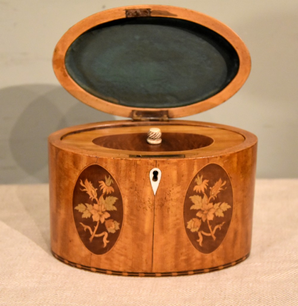 An 18th-century oval satinwood tea caddy featuring floral marquetry inlays, decorative stringing, and a bone keyhole escutcheon. View III