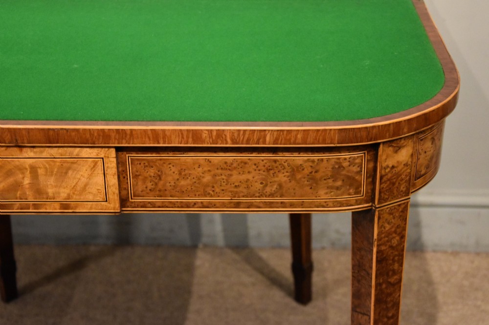 A George III fold-over card table with burr yew wood veneer, an oval central inlay, and square tapered legs. View III