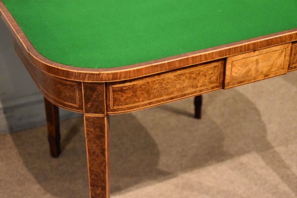 A George III fold-over card table with burr yew wood veneer, an oval central inlay, and square tapered legs. View IV