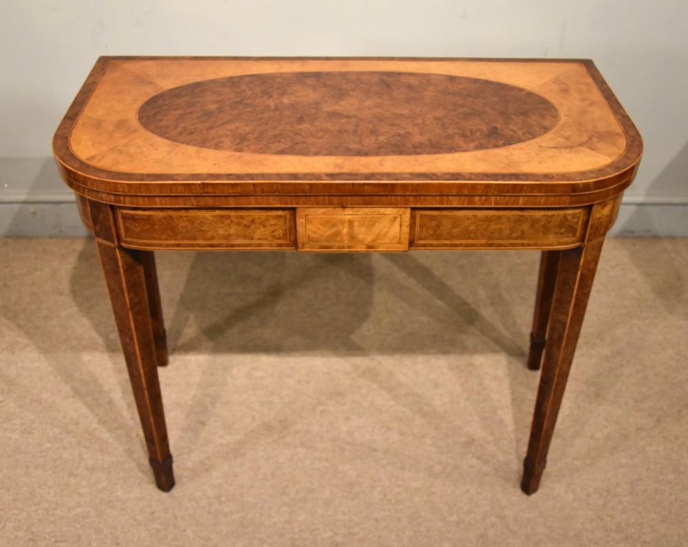 A George III fold-over card table with burr yew wood veneer, an oval central inlay, and square tapered legs. View VIII